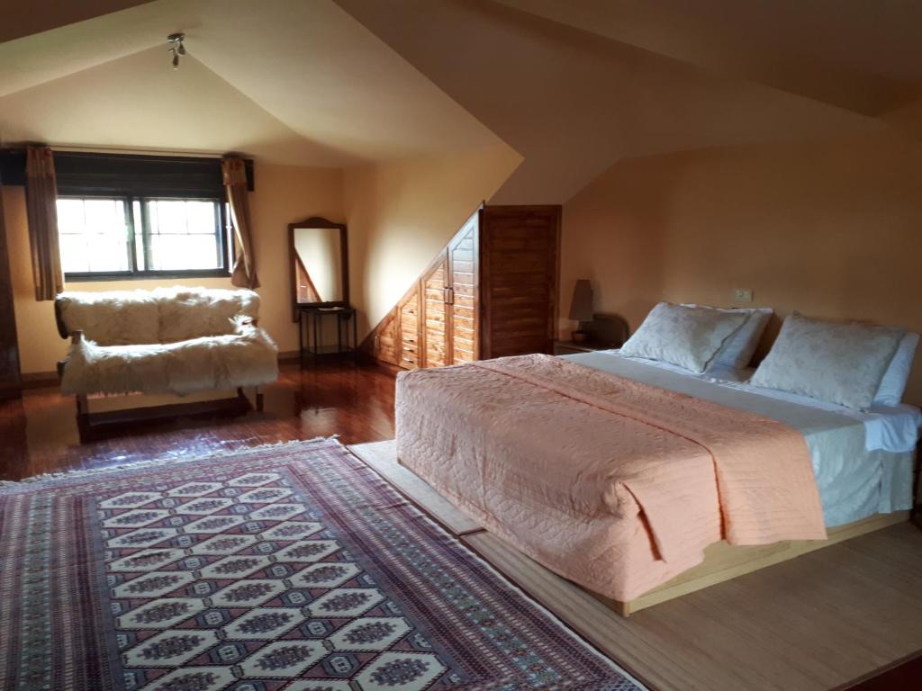 een slaapkamer met een bed, een stoel en een raam bij Casa Barciela in Pontevedra