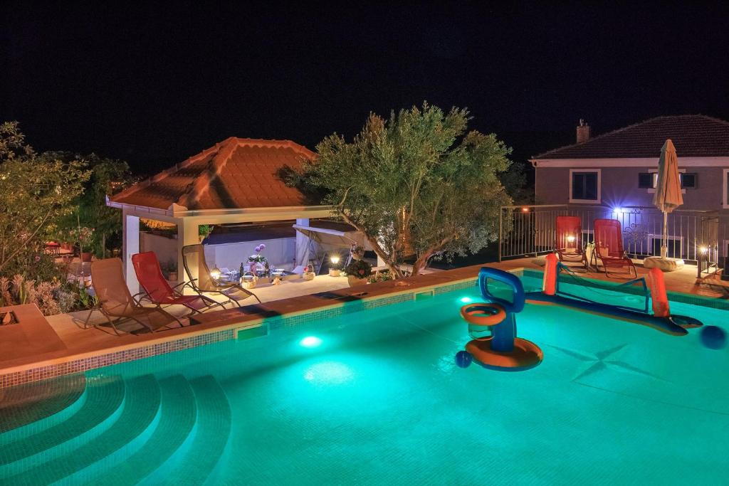 uma piscina vazia à noite com um parque infantil em Apartment Zeljana em Slatine