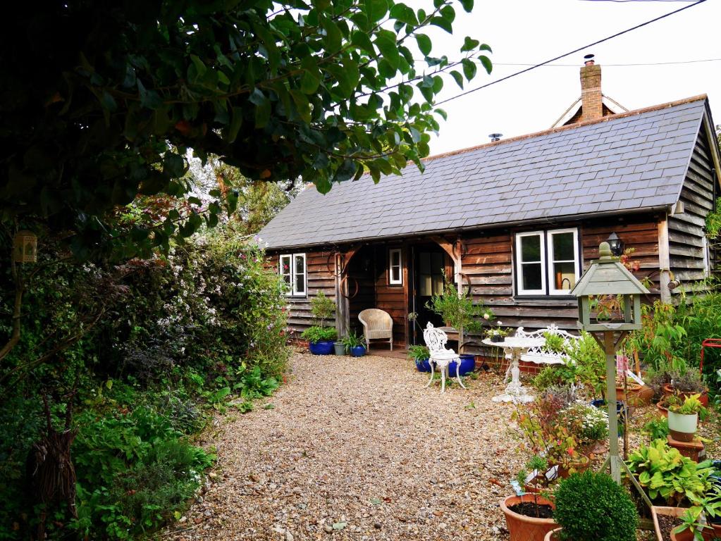 a log cabin with a pathway leading into the front yard at Wayside Cottage in Beaulieu