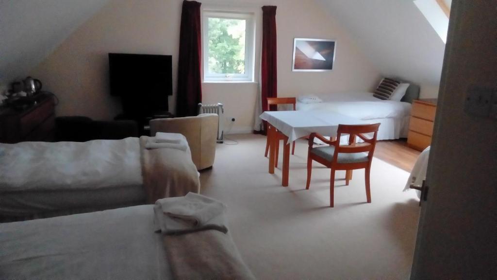 a living room with a bed and a table and chairs at Bluebell Cottage in Tarbert