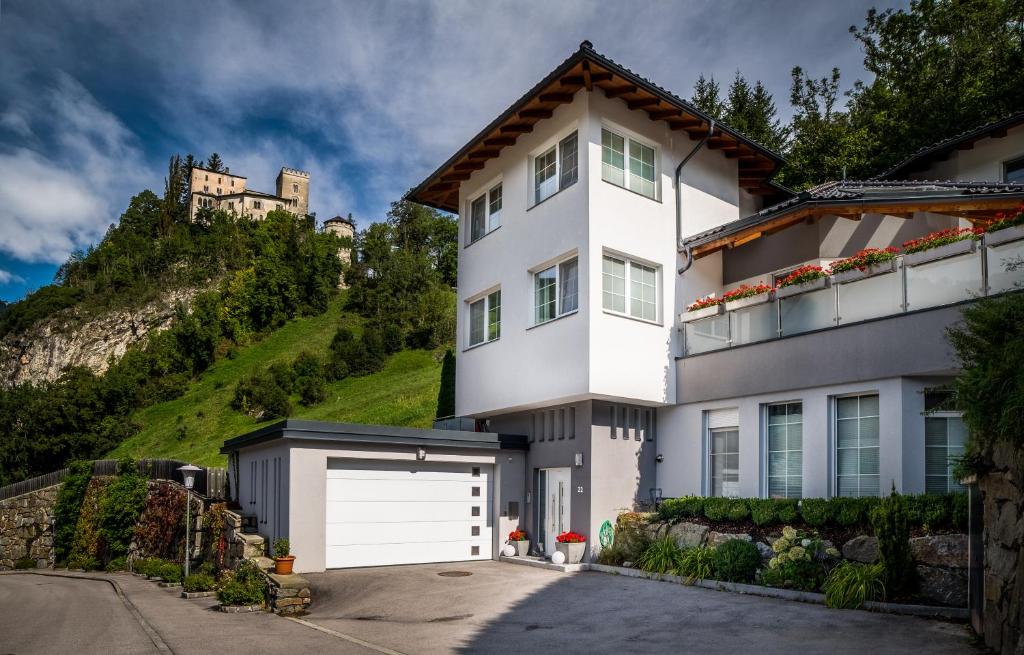 ein weißes Haus mit einer weißen Garage in der Unterkunft Apartments Schloß-Weißenstein-Straße in Matrei in Osttirol