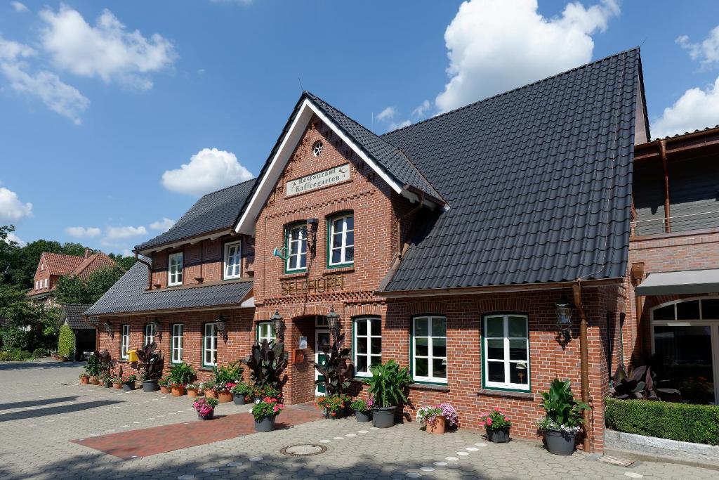 un edificio de ladrillo rojo con techo negro en Hotel Sellhorn, Ringhotel Hanstedt, en Hanstedt