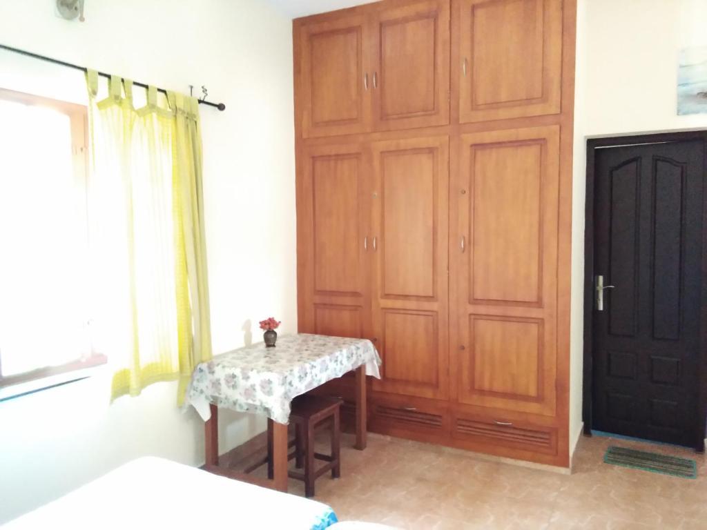 um quarto com uma mesa e uma porta de madeira em Birds Nest Home Stay em Cochin