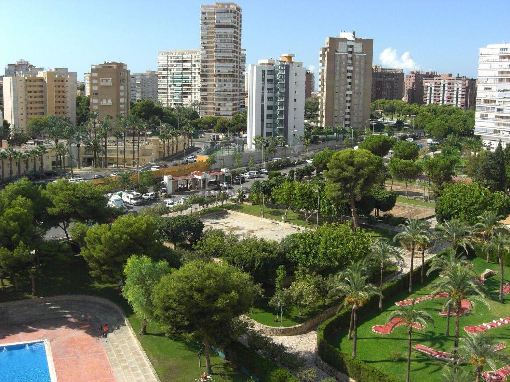 a park in a city with tall buildings at Apartamentos Club del Mar San Juan Beach in Alicante