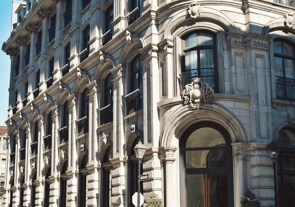 een groot wit gebouw met een boog ervoor bij Hotel Gault in Montreal