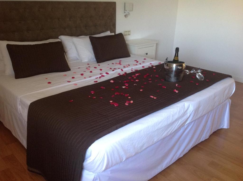 a bed with a black blanket with red flowers on it at Apartment Valle de Cepeda in Cepeda