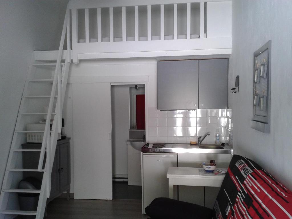 una pequeña cocina con una cama elevada en una habitación en Le Mas du Vieux Chene, en Saint-Paul-en-Forêt