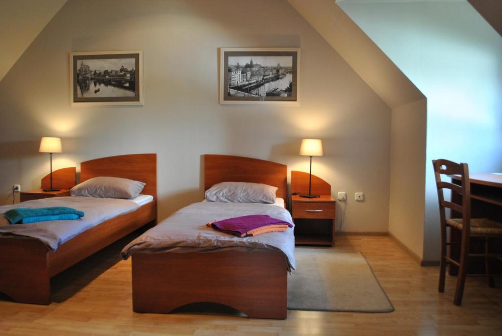 a bedroom with two beds and a table and chairs at House Na Kashtanovoj in Kaliningrad