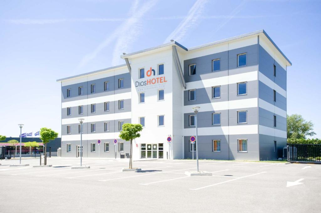 a large white building with a sign on it at Dios Hotel in Bruguières