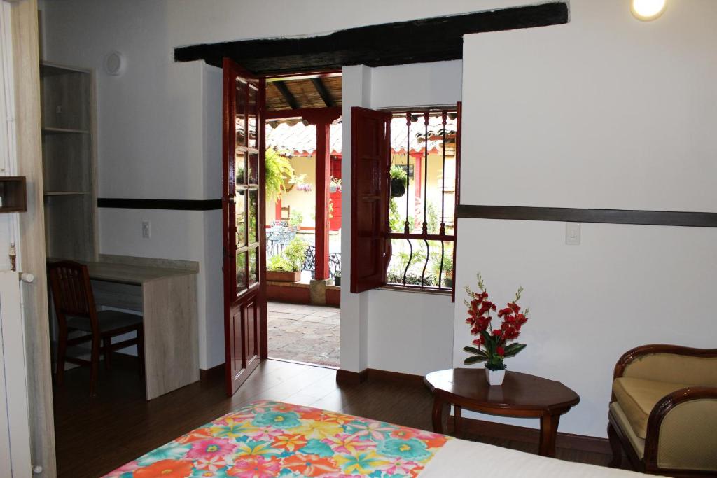 a bedroom with a bed and a table and a desk at Hotel Cacique Real in Zipaquirá