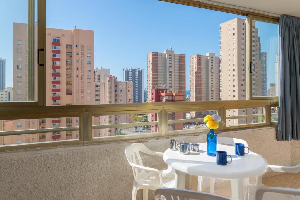 a table and chairs on a balcony with a view of a city at Apartamentos Mariscal 4 y 5 by Gestaltur in Benidorm