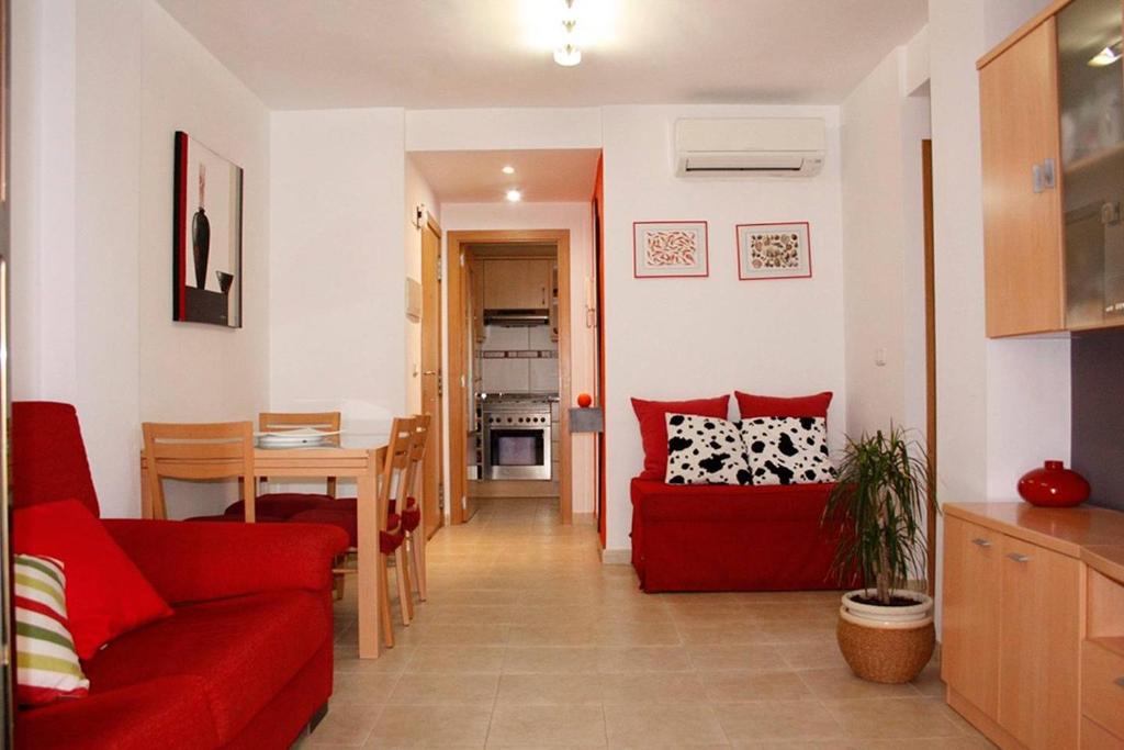 sala de estar con sofá rojo y mesa en Apartamento junto al mar Los Marineros con acceso independiente por terraza, en Puzol