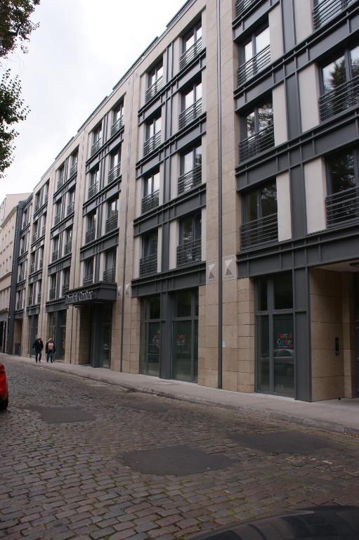 a large building on a street with people walking in front at LM Apartamenty Mariacka Stare Miasto in Szczecin