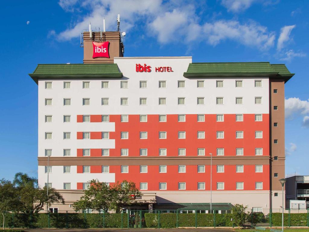 阿雷格里港的住宿－阿雷格里港機場宜必思酒店，一座红色和白色的大建筑,上面有公共汽车标志