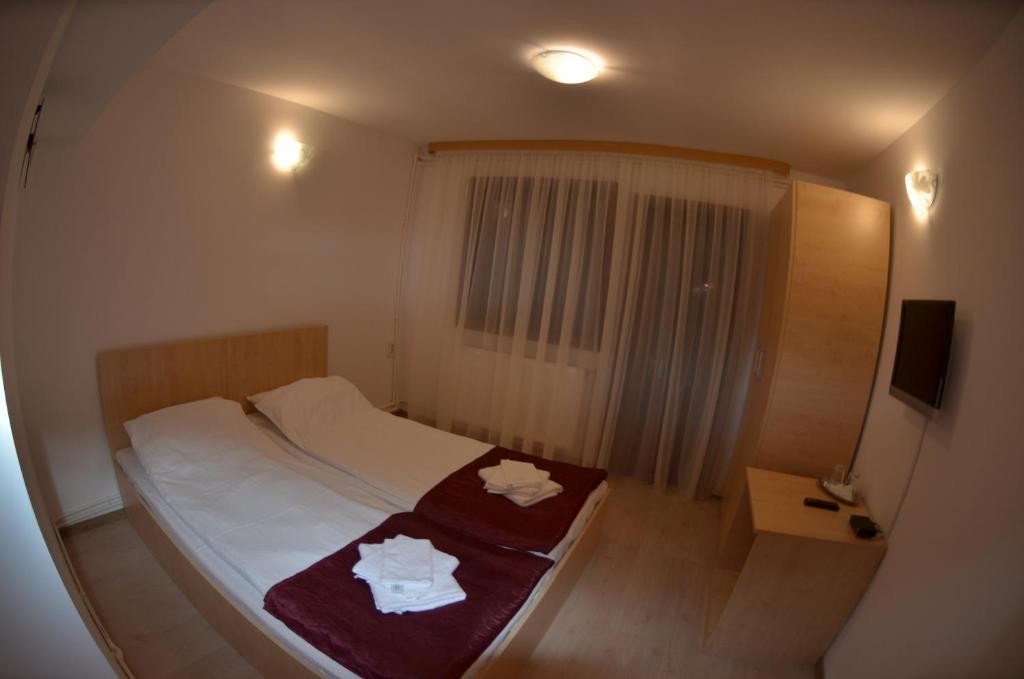 1 dormitorio pequeño con 1 cama con 2 toallas en Popas Azuga, en Azuga