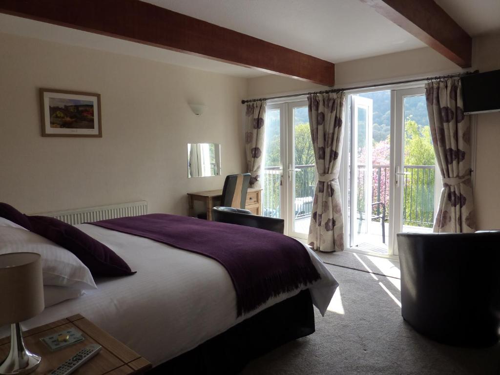 a bedroom with a bed and a large window at Maes-y-Garth in Betws-y-coed