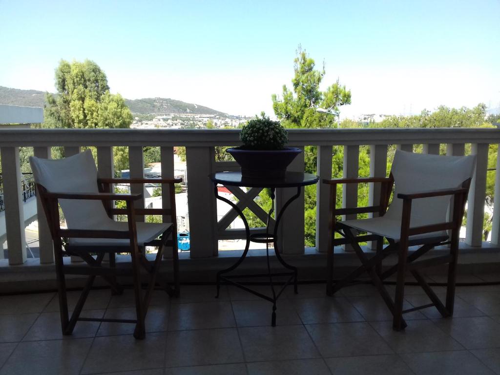 a table and chairs on a balcony with a potted plant at Blue Sky appartment in Pallíni