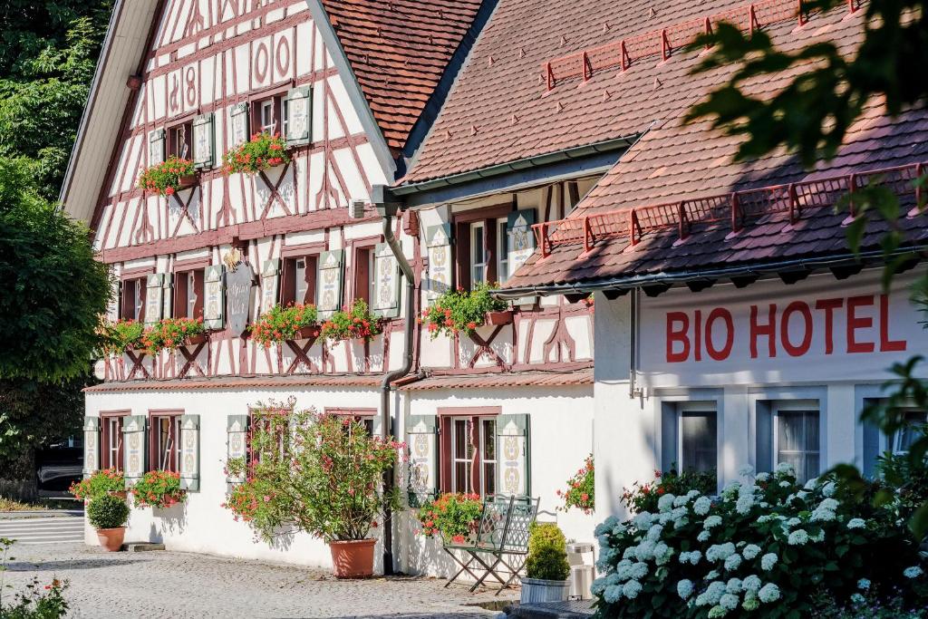 ein Gebäude mit einem großen Haus mit Blumen davor in der Unterkunft BIO-Hotel Adler/Restaurant in Vogt