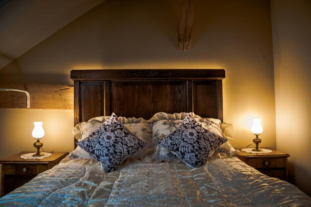 ein Schlafzimmer mit einem Bett mit Kissen und zwei Lampen in der Unterkunft Siedlisko Jagiele in Jagiele