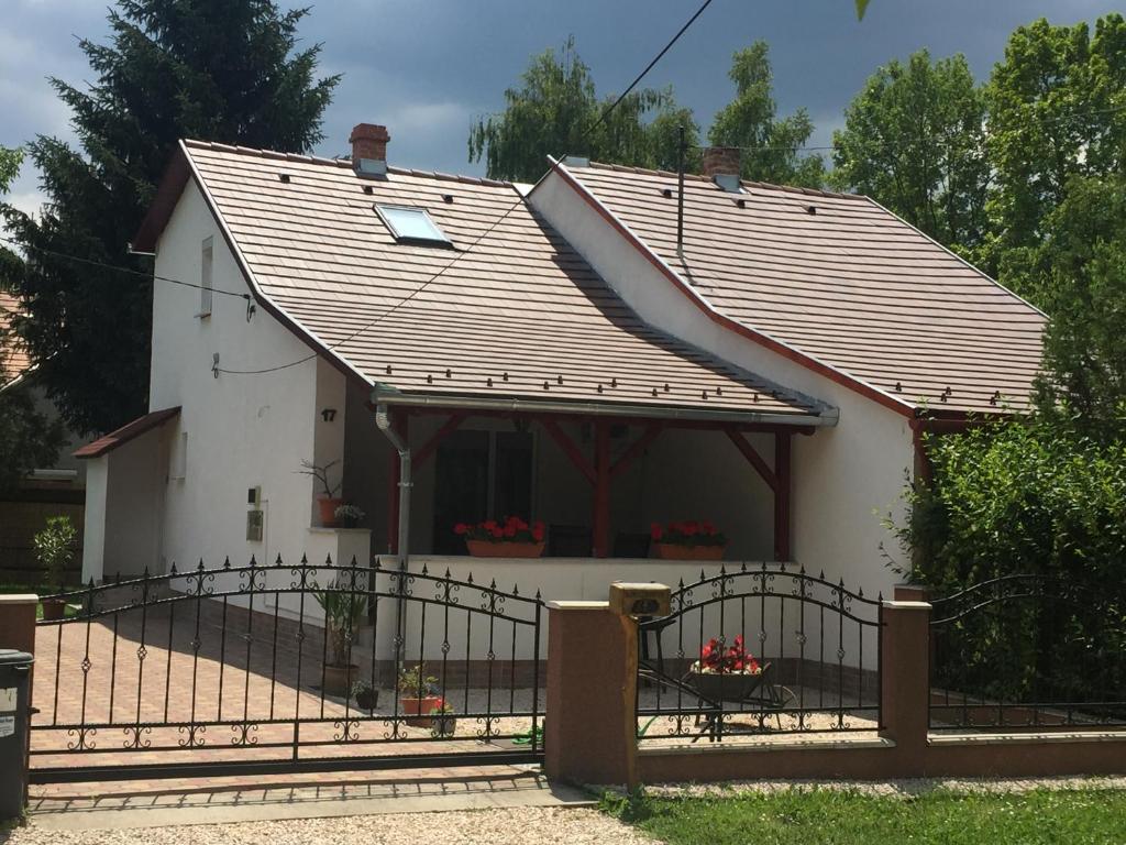 a small white house with a metal fence at Arborétum in Harkány