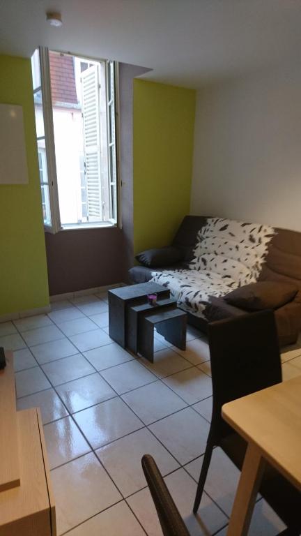ein Wohnzimmer mit einem Bett und einem Tisch in der Unterkunft Le Jim : Rue Musette in Dijon