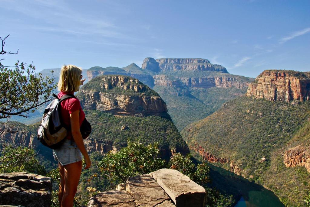 a woman standing on a rock overlooking the grand canyon at Joy River Backpackers in Moremela