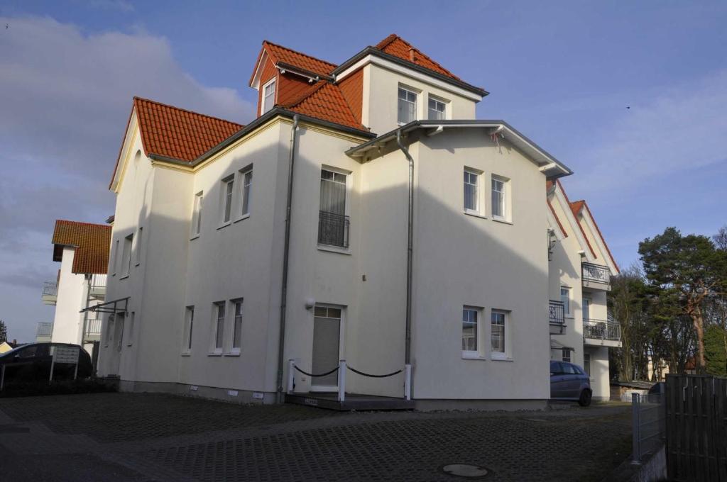 アールベックにあるEG 05 Ferienwohnung am Wilhelmsbergの通り沿いのオレンジ色の屋根の白い家