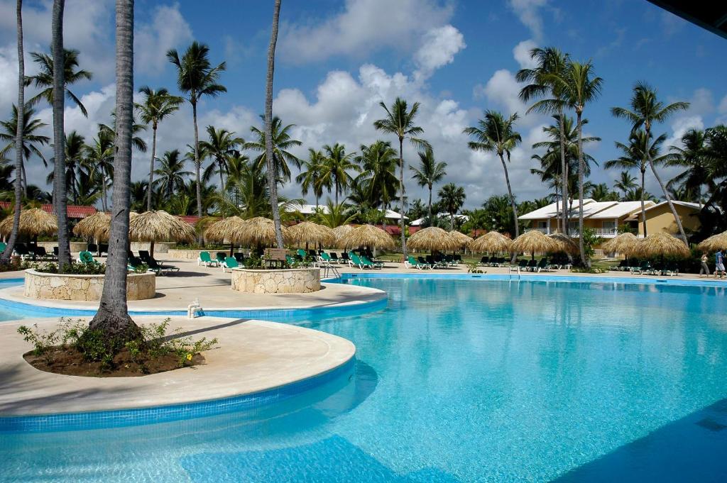 a pool at a resort with palm trees at Grand Palladium Bavaro Suites Resort & Spa - All Inclusive in Punta Cana
