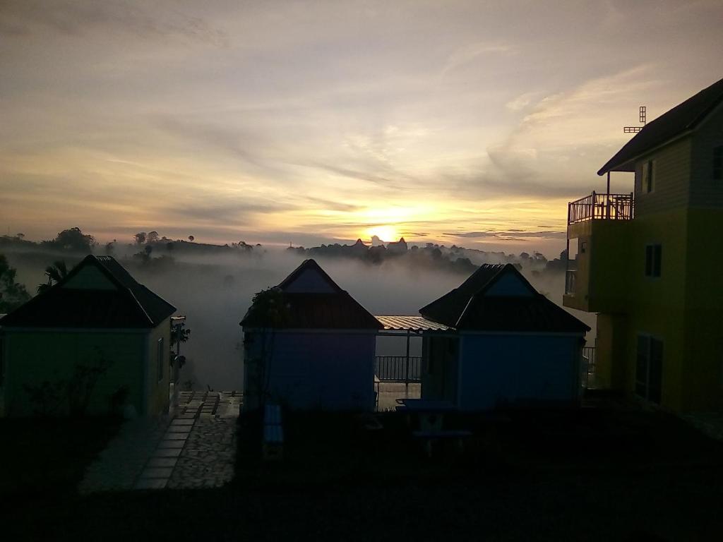 Blick auf den Sonnenaufgang mit Nebel in der Ferne in der Unterkunft Lovely Farm in Khao Kho