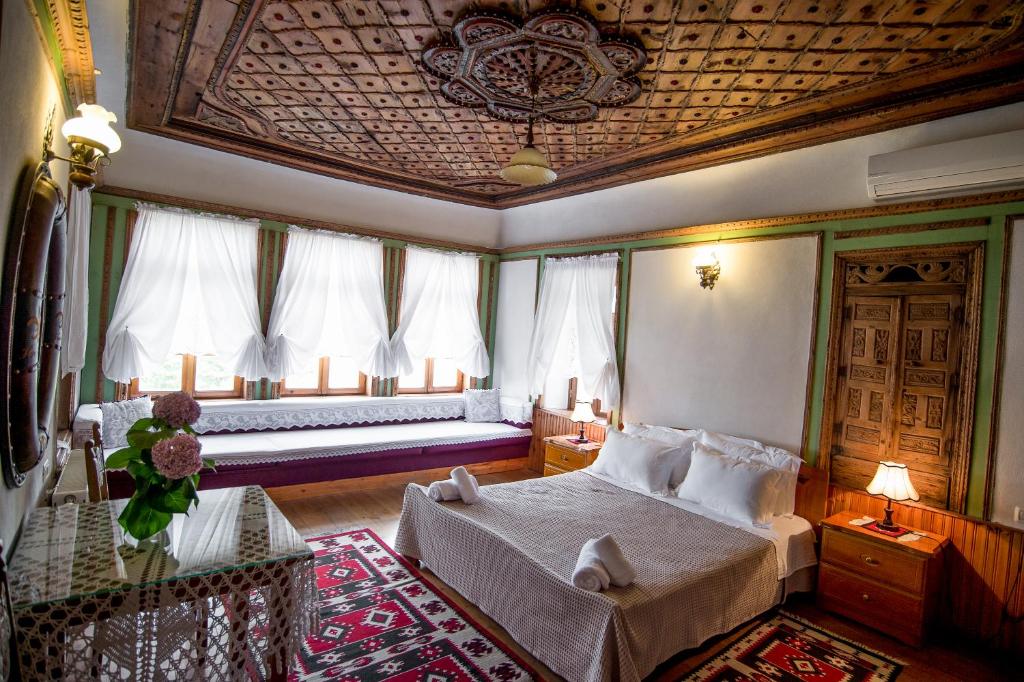 1 dormitorio con 1 cama en una habitación con ventanas en Hotel Kalemi, en Gjirokastra