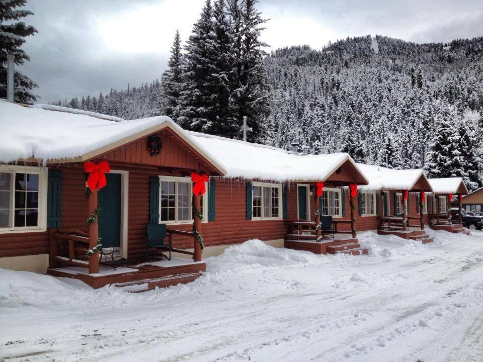 a resort cabin in the snow with red bows at Three Bears Lodge in Red River