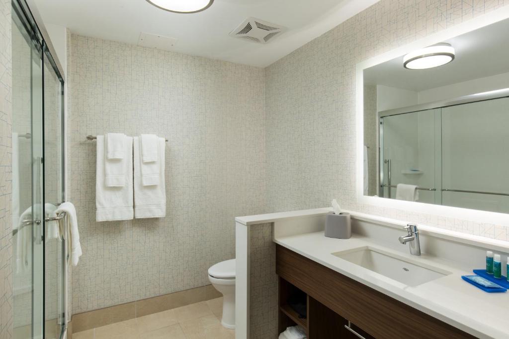 a bathroom with a sink and a toilet and a mirror at Holiday Inn Express Visalia-Sequoia Gateway Area by IHG in Visalia