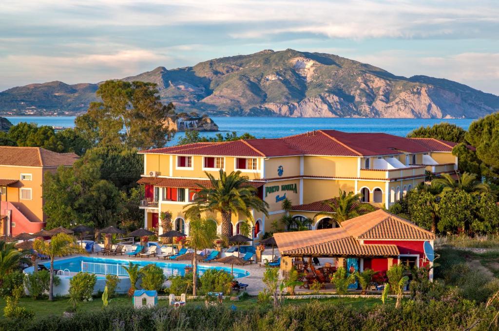 ein Resort mit Pool und Bergen im Hintergrund in der Unterkunft Porto Koukla Beach in Lithakia