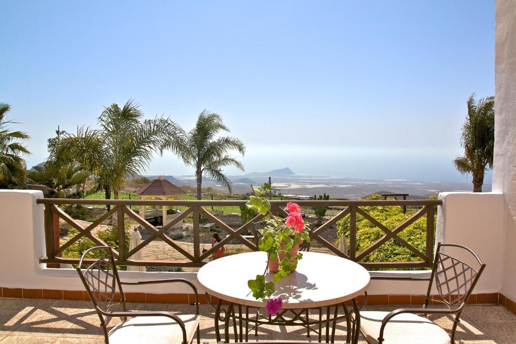 a table and chairs on a balcony with a view at Eco Finca Vista Bonita in San Miguel de Abona
