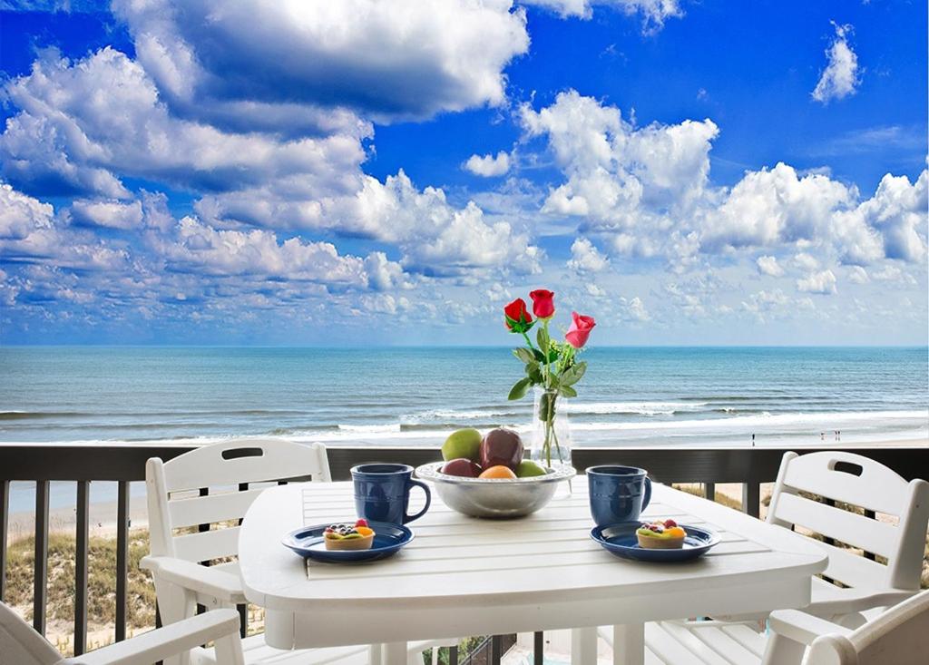アメリア・アイランドにあるAmelia Island Oceanfront 2 Master Suitesの海を望むバルコニーにテーブルとフルーツを用意しています。