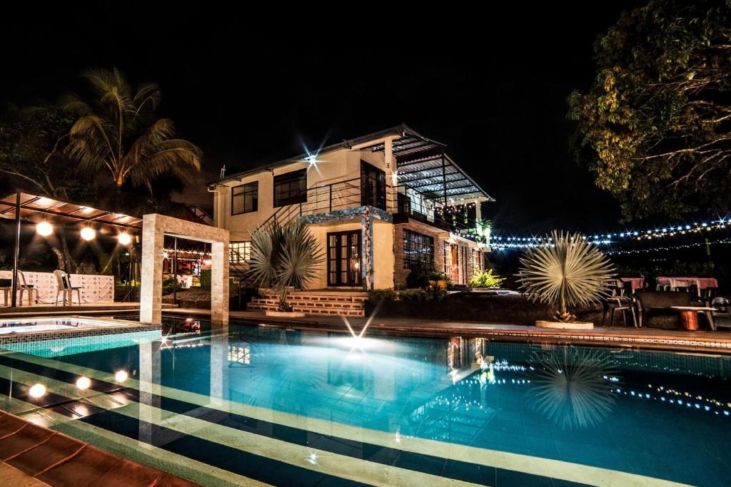 une maison avec une piscine la nuit dans l'établissement Nuevo Oeste, à Acacías
