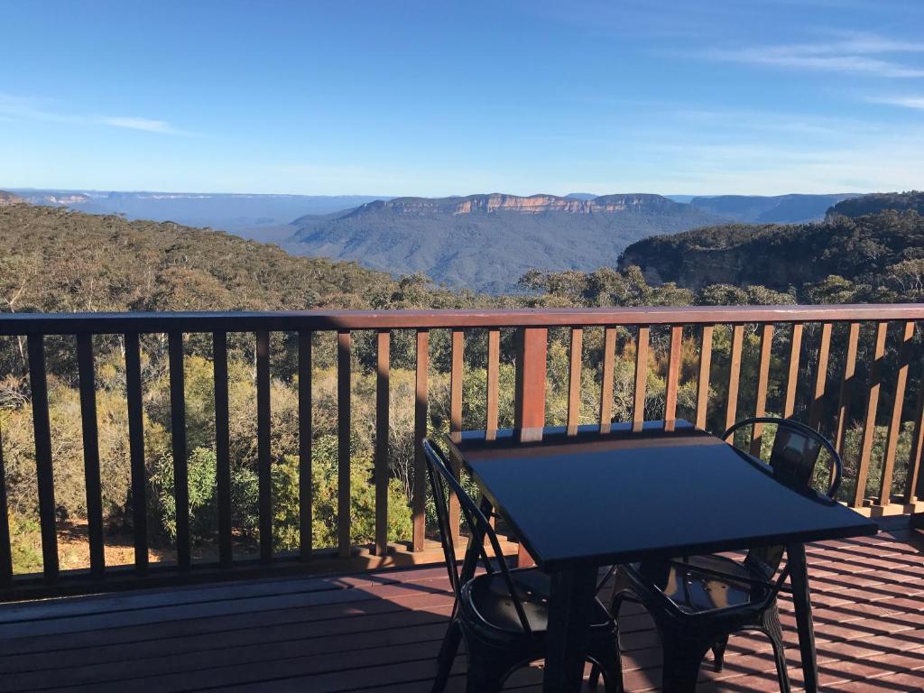 a picnic table on a deck with a view of the mountains at Valley of the Waters B&B in Wentworth Falls