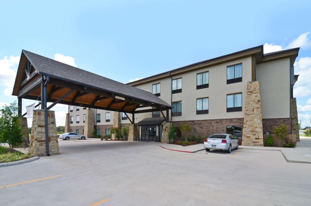 ein Gebäude mit einem Auto auf einem Parkplatz in der Unterkunft Best Western Plus Emory at Lake Fork Inn & Suites in Emory