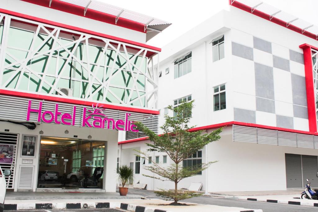 a building with a halo karma sign on it at Hotel Kamelia in Kepala Batas