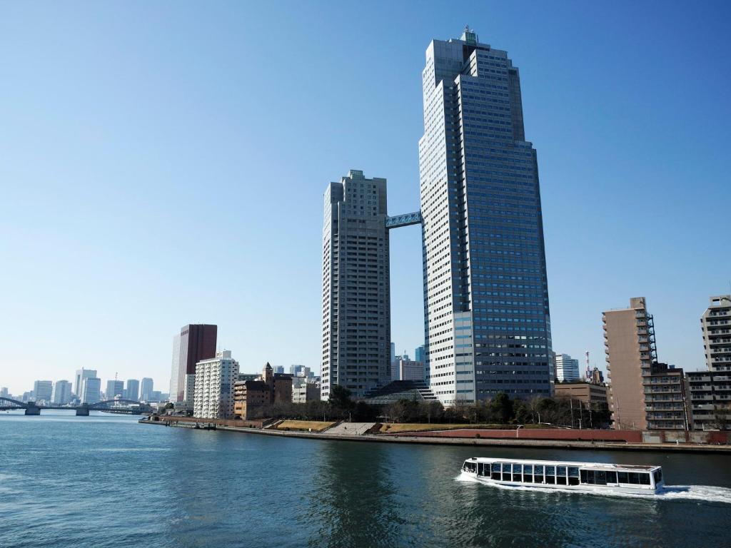 un barco en el agua en una ciudad con edificios altos en Ginza Creston, en Tokio