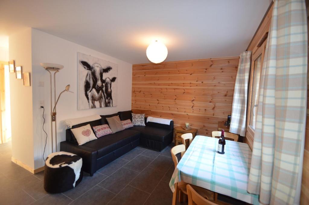 uma sala de estar com um sofá e uma mesa em Le Nid de Martinet em Grimentz