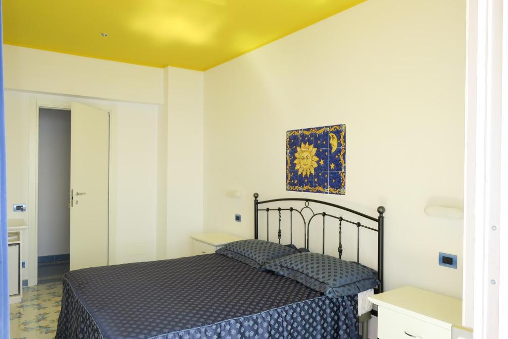 ヴィエトリにあるCasa Amorevoleのベッドルーム1室(ベッド1台付)が備わります。壁には絵画が飾られています。