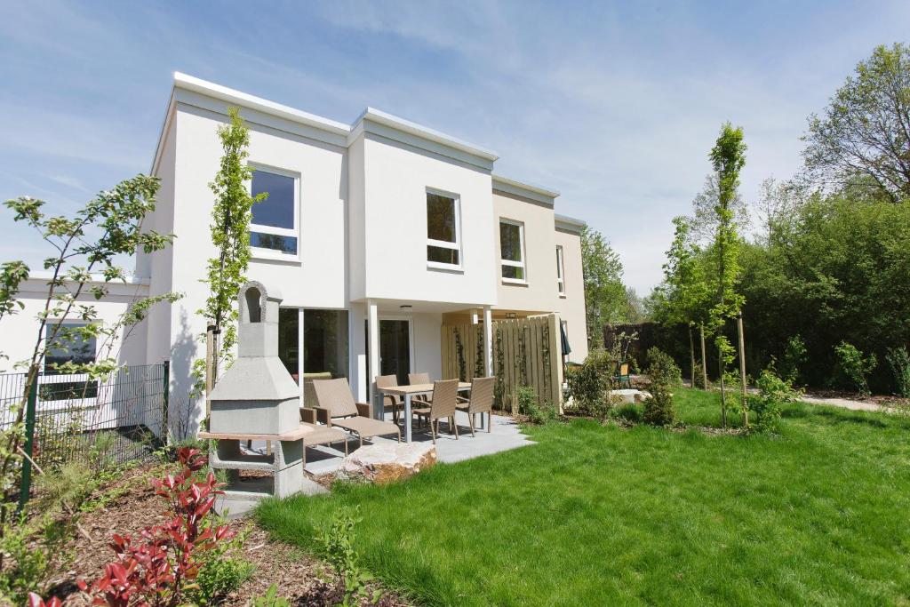 a white house with a table and chairs in the yard at Center Parcs Bostalsee Saarland in Nohfelden