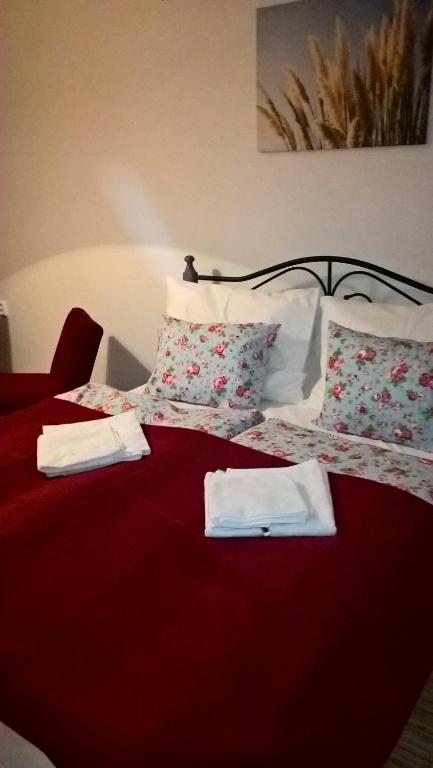 a bedroom with two beds with red sheets and pillows at Apartmany Žatec in Žatec