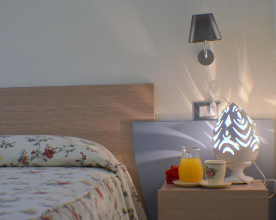a bedroom with a bed with a lamp and two glasses of orange juice at Masseria Asciano in Ostuni