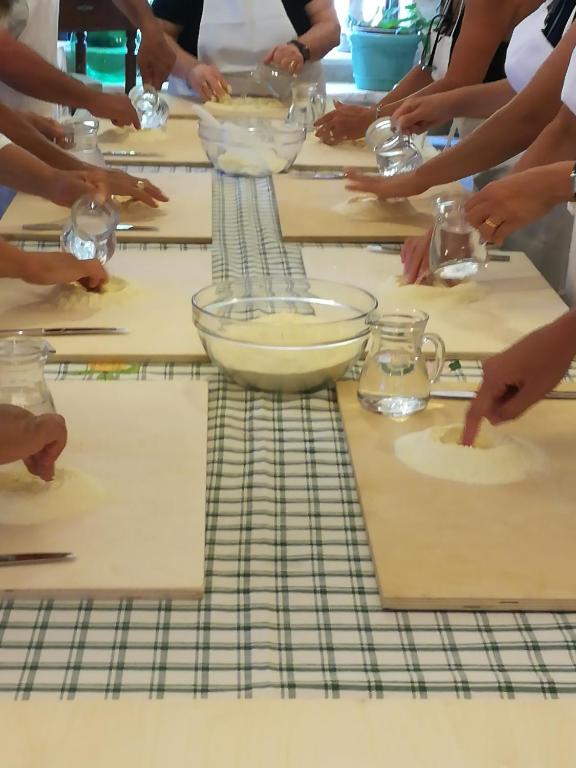 a group of people sitting around a table preparing food at Masseria Asciano in Ostuni