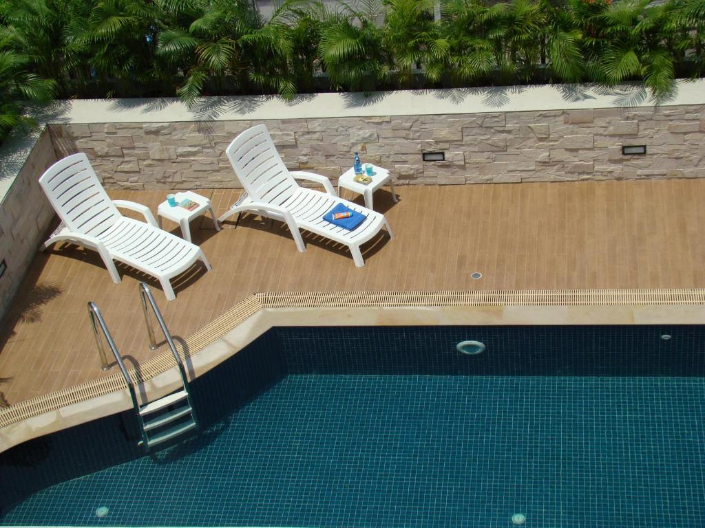 2 sillas y una mesa junto a la piscina en Bangkok Living, en Bangkok