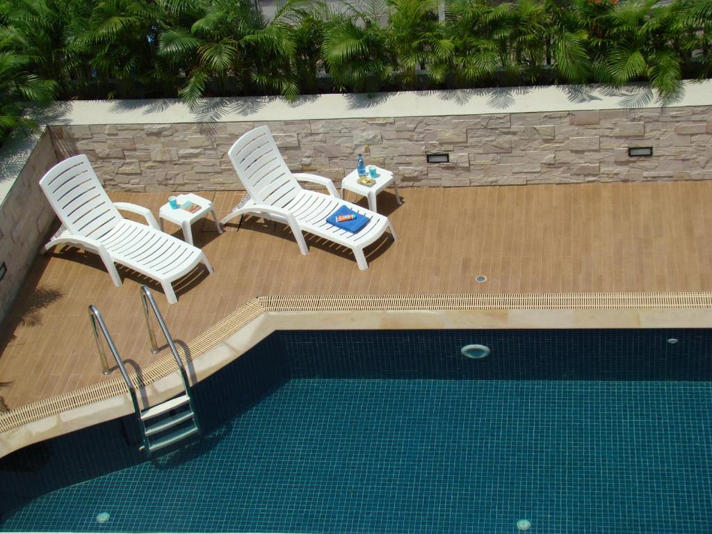 two chairs and a table next to a swimming pool at Bangkok Living in Bangkok