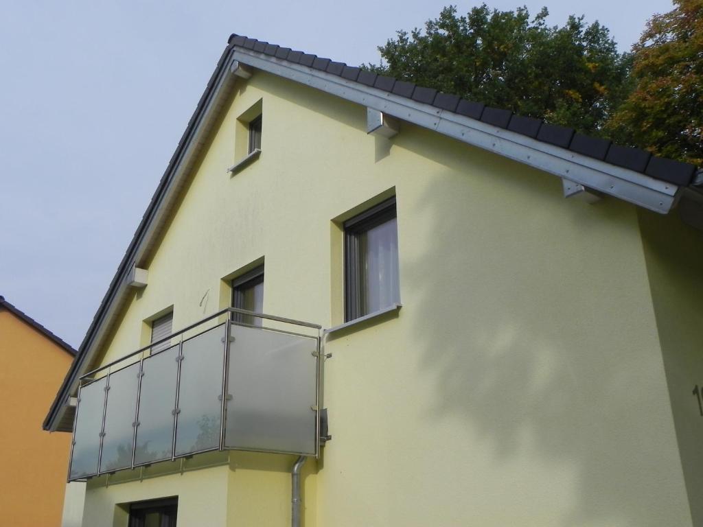 un edificio amarillo con un balcón en el lateral. en 1-Zimmer-Wohnung Nähe Playmobil Funpark, en Oberasbach