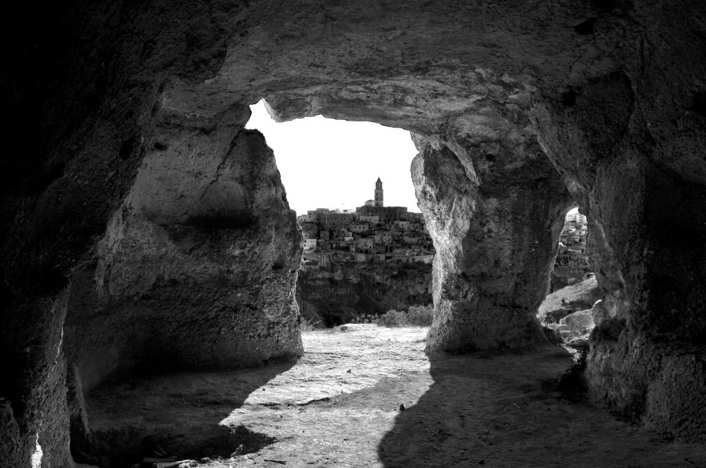 ein schwarz-weißes Foto einer Höhle mit Fenster in der Unterkunft B&B La Gemma dei Sassi in Matera